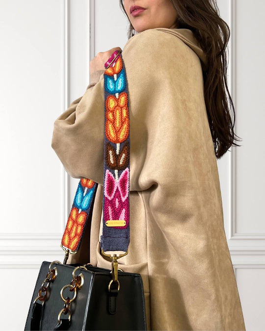 Detailaufnahme der Stickerei und Schnalle des handbestickten Ayni Ppacha Taschengurts 'Tulipán' aus Schafwolle, blau/bunt mit Tulpenmuster.