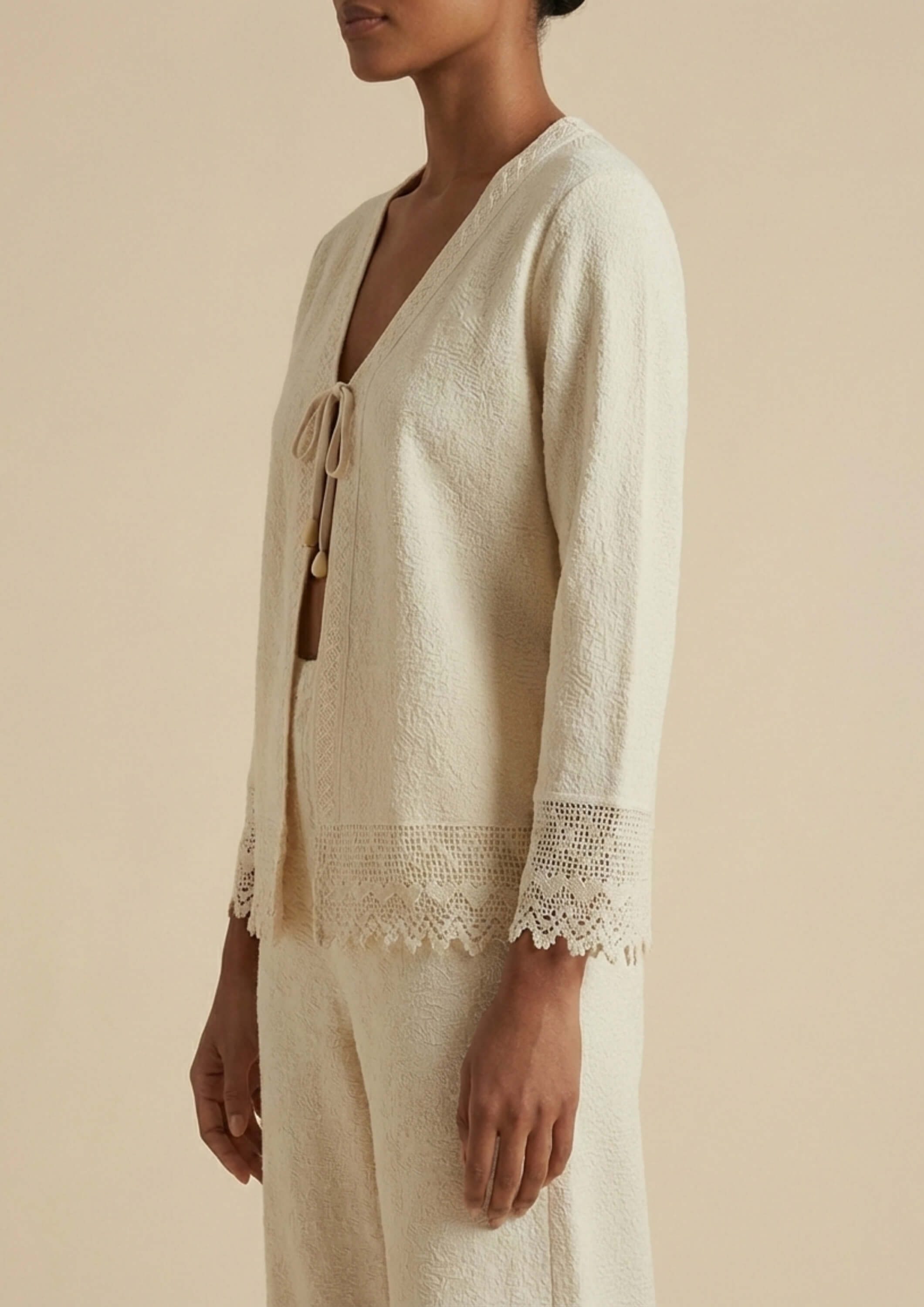 Der beige Cardigan 'Garbo' von Ayni Ppacha aus 100% ungefärbter Baumwolle auf in der Seitenansicht.