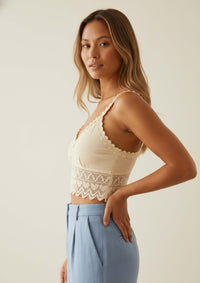 Seitenansicht des Gracia Crop Tops von Ayni Ppacha. Die Aufnahme zeigt den fließenden Übergang von der strukturierten Tanguis-Baumwolle zur zart durchscheinenden Häkelspitze am Saum. Ein baukastenartiges Investment-Piece ohne Synthetik, das für zeitlose Eleganz und textile Tiefe steht.