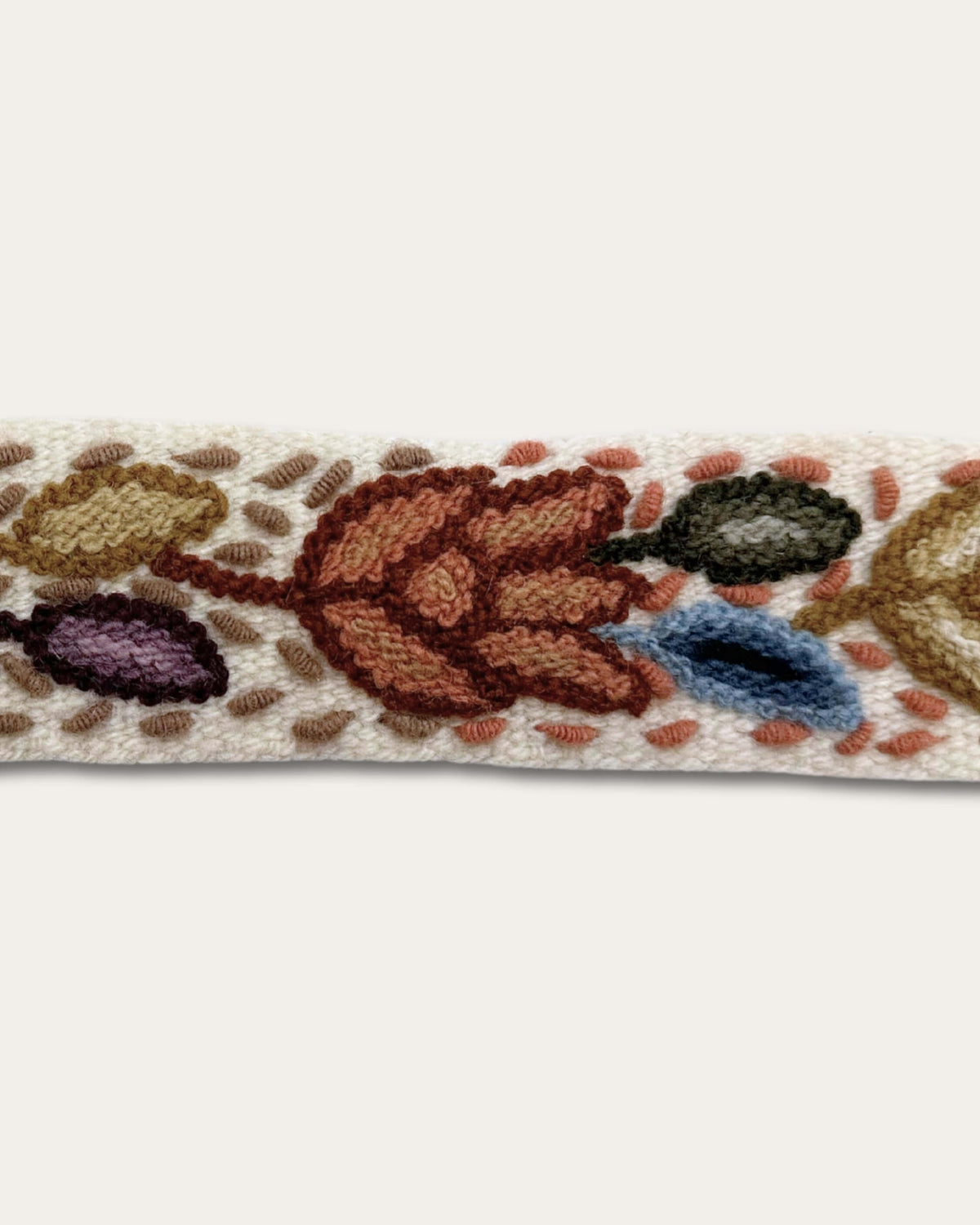 Detail der Handstickerei am Gürtel Azulina: dicht gesetzte Stiche aus naturgefärbter Schafwolle auf naturweißem Grundgewebe