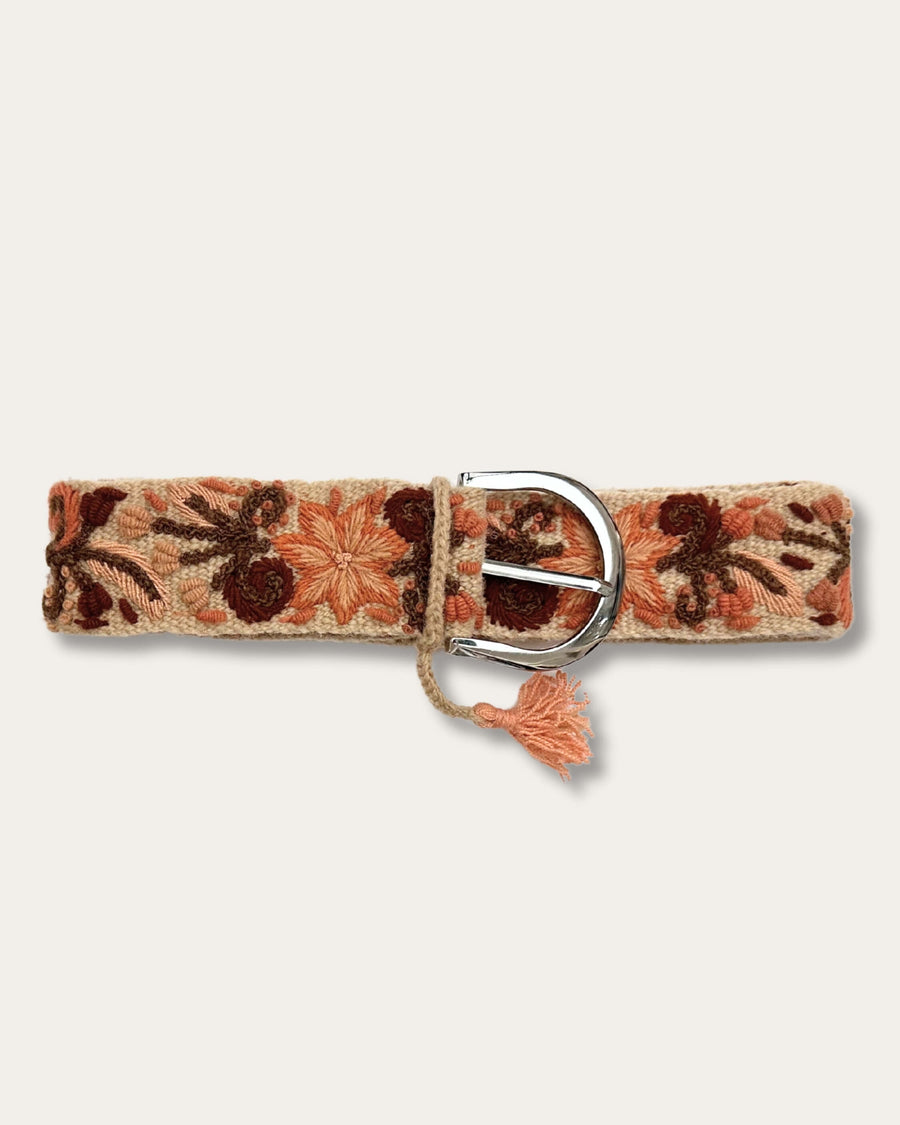 Gürtel Otoño von Ayni Ppacha geschlossen: sandfarbene Schafwolle, handbestickt mit Blüten und Ranken in Terrakotta, Apricot und Rotbraun, silberfarbene D-Schnalle mit Quaste