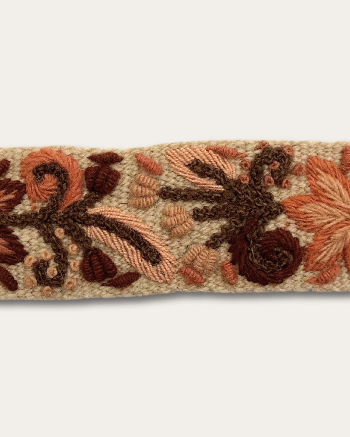 Detail der Handstickerei am Gürtel Otoño: dicht gesetzte Stiche aus naturgefärbter Schafwolle auf sandfarbenem Grundgewebe