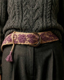 Harmonischer Materialmix: Der handgefertigte Gürtel 'Violeta' aus Wolle setzt einen farbigen Akzent in Violett auf einem grauen Winter-Outfit.