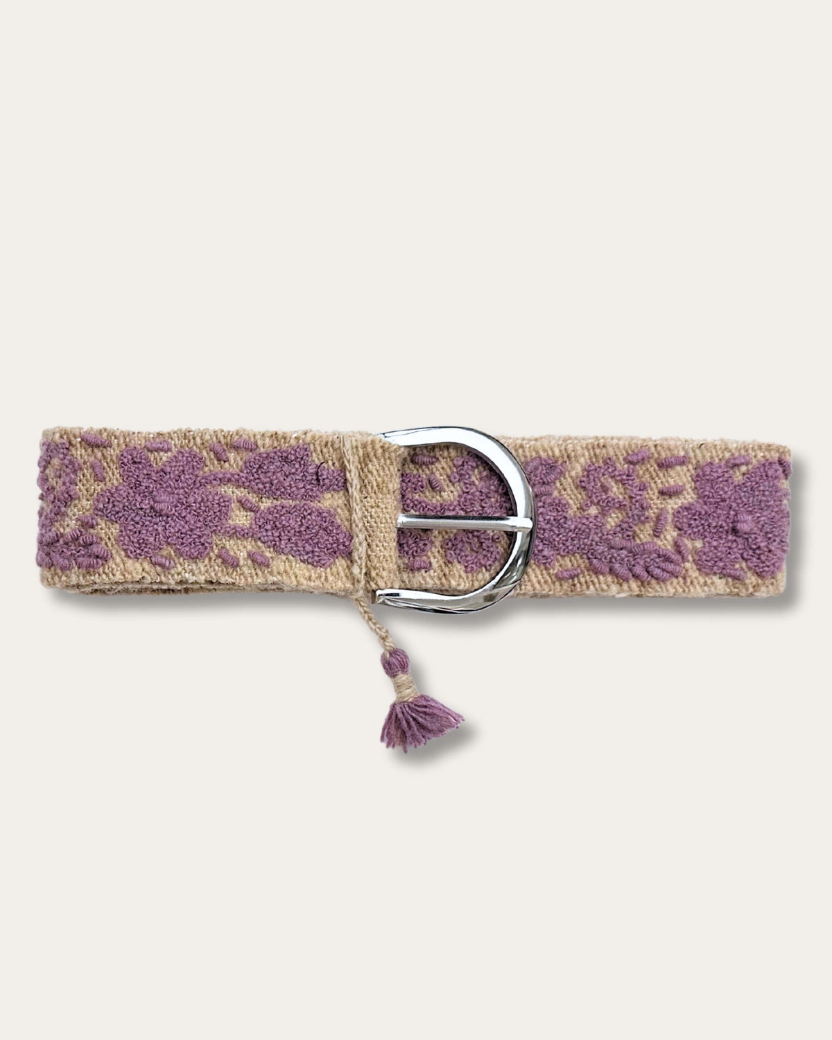 Gürtel Violeta von Ayni Ppacha geschlossen: sandfarbene Schafwolle, handbestickt mit Blüten und Ranken in Violett, silberfarbene D-Schnalle mit Quaste