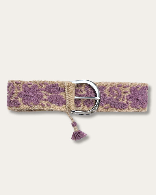 Gürtel Violeta von Ayni Ppacha geschlossen: sandfarbene Schafwolle, handbestickt mit Blüten und Ranken in Violett, silberfarbene D-Schnalle mit Quaste
