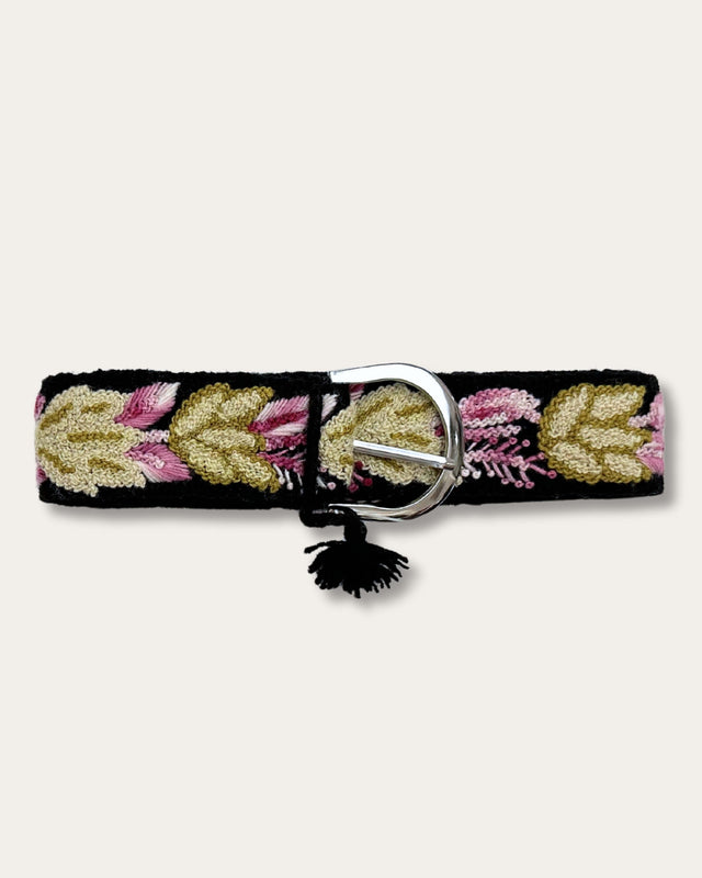 Gürtel Yagua von Ayni Ppacha geschlossen: schwarze Schafwolle, handbestickt mit Blättern in Gold, Oliv und Rosa, silberfarbene D-Schnalle mit Quaste
