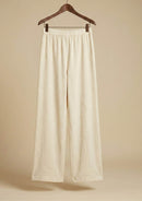 Die beige Hose 'Pradera' von Ayni Ppacha aus 100% ungefärbter Baumwolle, freigestellt am Bügel. Sichtbar ist der klassische Straight-Leg-Schnitt und der komfortable High-Waist-Bund.