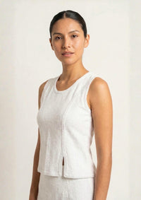 Nahaufnahme des Ayni Ppacha Tops 'Baila' in Weiß. Die architektonische Textur des Nazca-Webstoffs und der cleane Rundhalsausschnitt betonen den High-Fashion-Anspruch dieses Essentials.